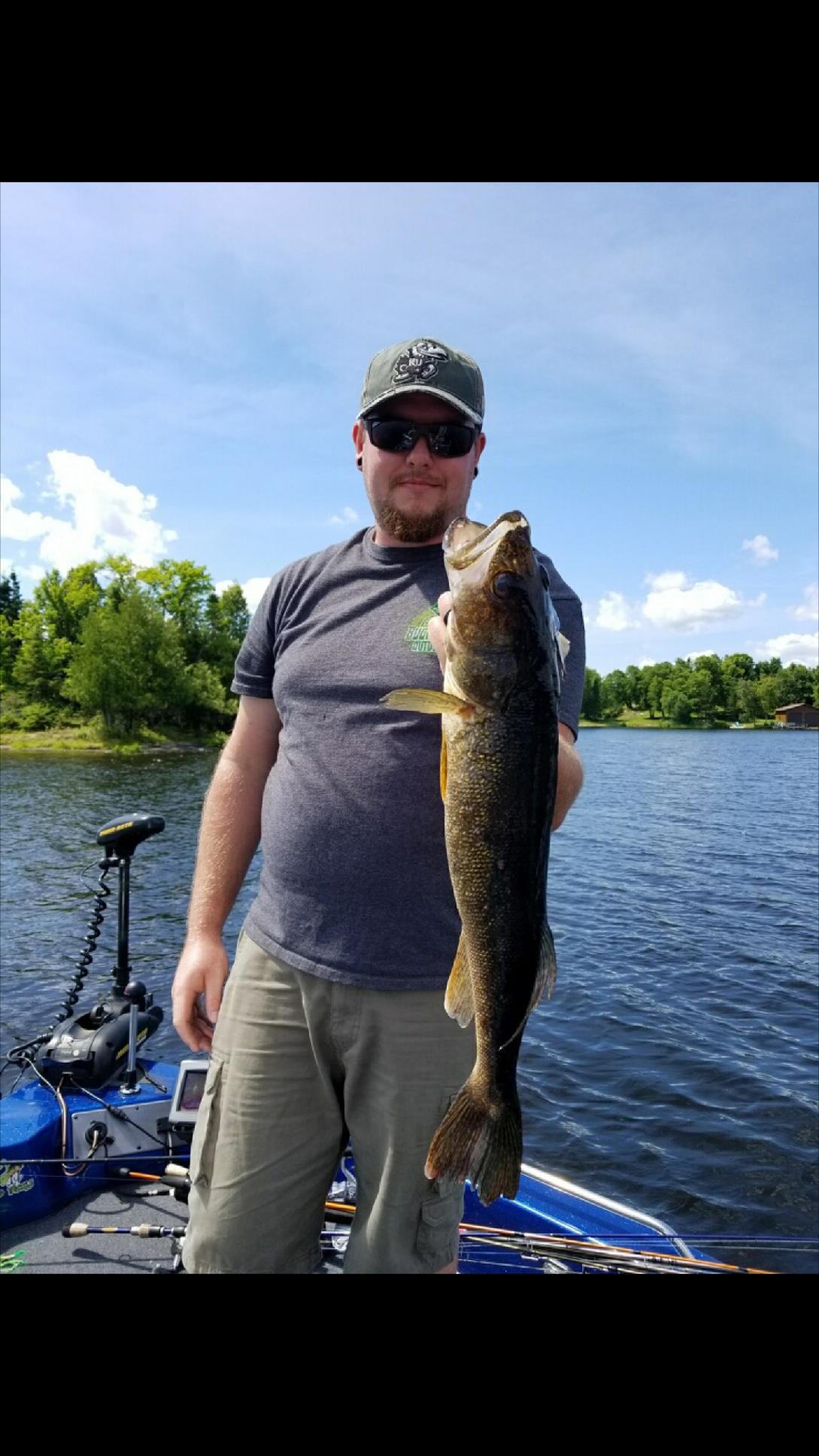 Guy holding up a wallet with one hand on a nice sunny day on the water